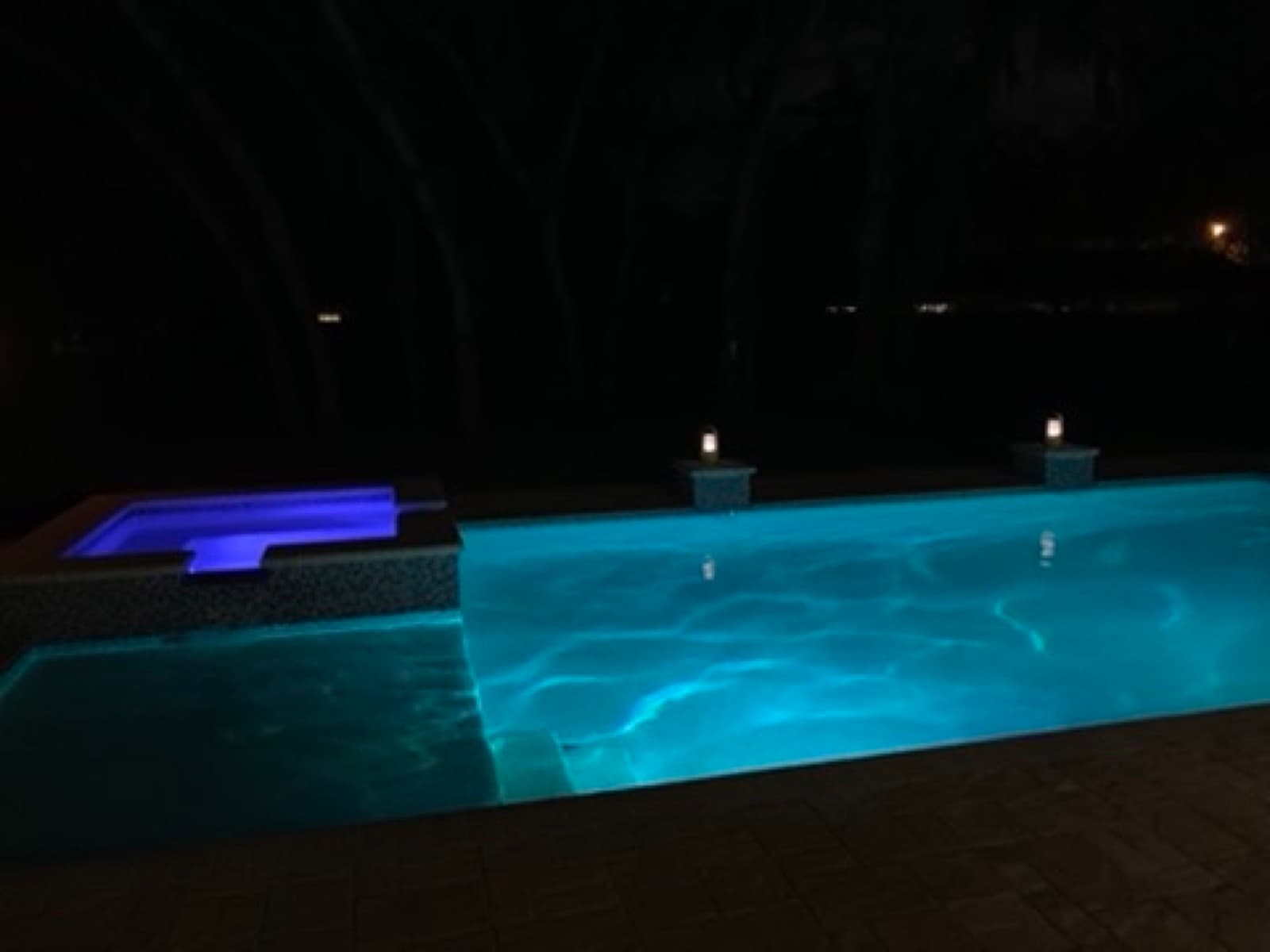 Pool and hot tub lit up at night